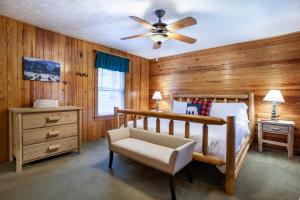 1 dormitorio con paredes de madera, 1 cama y ventilador de techo en Quietside Cabin Grill Fire Pit Fireplace, en Walland