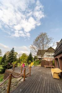 a wooden deck with yellow chairs and a building at Hotel Niedersächsischer Hof in Bad Bentheim