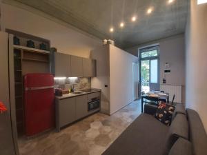 a kitchen with a couch and a red refrigerator at Borromini Home in Turin