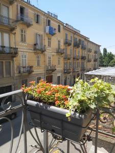 a planter filled with flowers on top of a balcony at Borromini Home in Turin