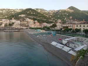 uma praia com um grupo de cadeiras e a água em TakeAmalfiCoast Minori Center em Minori