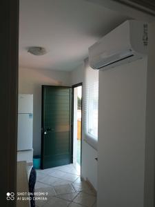 um corredor com uma porta verde numa cozinha em B&B Saturno em Marina di Camerota