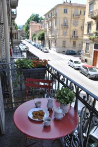 a red table with a plate of food on a balcony at Borromini Home in Turin +3 photos