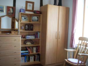 a bedroom with a book shelf and a dresser at La Châtaigne Dorée in Saint-Pierre-de-Fursac