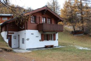 a house with a porch and a bench in front of it at Chalet Zwächta in Zermatt