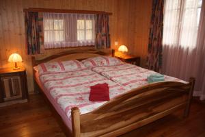 1 cama en un dormitorio con 2 lámparas y 2 ventanas en Chalet Zwächta, en Zermatt