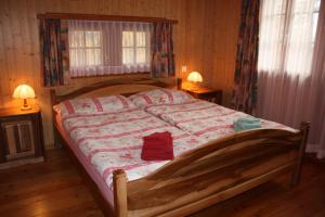 a bed in a bedroom with two lamps and two windows at Chalet Zwächta in Zermatt