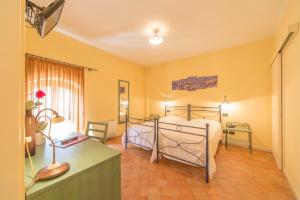 a bedroom with a bed and a desk with a lamp at Hotel Antichi Cortili in Dossobuono