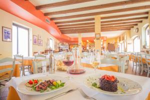 Hotel Antichi Cortili في دوسّوبونو: مطعم مع طبقين من الطعام على طاولة