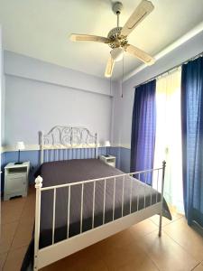 um quarto com uma cama e uma ventoinha de tecto em Grand Apartments em Néa Koróni