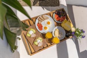 a breakfast tray with eggs and bread and fruit at Suites D´aldeia - Suite 16 in Mafra