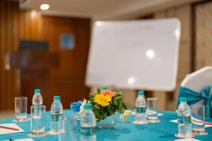 a table with bottles and a vase of flowers on it at Cygnett Resort Mountain Breeze in Nainital