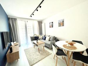 a white living room with a table and a couch at Apartament Nadmorski - Plac Unii - Parking in Gdynia