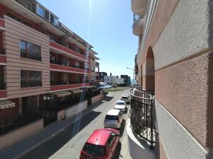 a row of cars parked on a street next to a building at Belisima 204 B in Ravda +23 photos