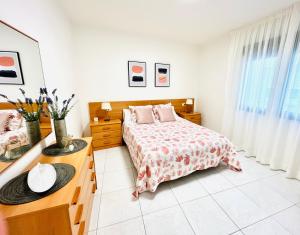 um quarto branco com uma cama e uma cómoda em Apartamentos Faro da Rocha em O Grove