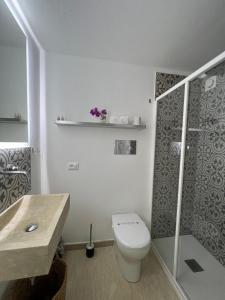 a white bathroom with a toilet and a shower at Castello a Mare in Castellammare del Golfo