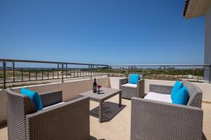 Un balcón con sillas y una mesa con una botella de vino. en Sea Point Villas, en Bahía de Coral