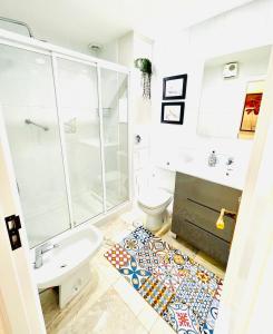 uma casa de banho com um chuveiro, um WC e um lavatório. em Apartamentos Faro da Rocha em O Grove