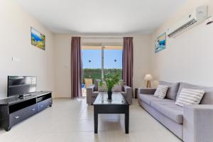ein Wohnzimmer mit einem Sofa und einem TV in der Unterkunft Sea Point Villas in Coral Bay