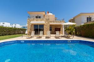 a swimming pool in front of a house at Sea Point Villas Luxury Villas with Private Pools in Coral Bay in Coral Bay