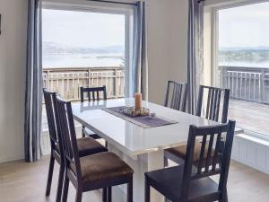 una mesa de comedor y sillas con vistas al océano en 8 person holiday home in Leka-By Traum, en Frøvik