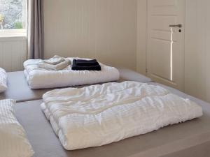 two white beds sitting on the floor in a room at Holiday home Leka II in Frøvik