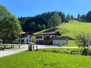 a house in the middle of a green hill at Landhaus Weiss in Sankt Martin am Tennengebirge