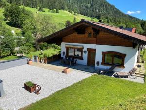 a small house in the mountains with a patio at Landhaus Weiss in Sankt Martin am Tennengebirge
