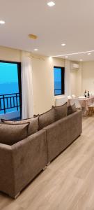 a living room with a large couch in front of windows at Blue Seaview Suites in Piraeus