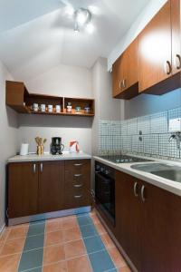 a kitchen with wooden cabinets and a sink at Hostel Day 'N' Night in Niš