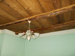 una lámpara de araña colgada de un techo de madera en La Neviera Nel Pozzo en Offida
