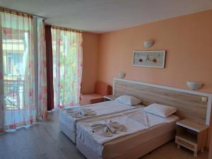 a bedroom with a bed and a large window at Copacabana Hotel in Ravda