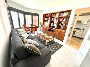 uma sala de estar com um sofá e uma mesa em Apartamentos Faro da Rocha em O Grove