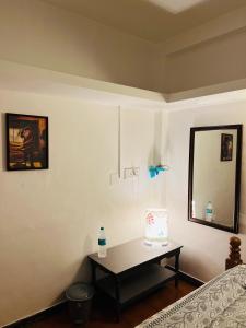 a bedroom with a table and a mirror on the wall at La Ruelle Guest House in Puducherry