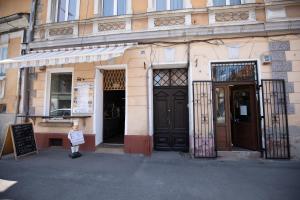 a woman standing in front of a building with two doors at Studio Manzur in Braşov