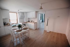 a kitchen with white cabinets and a table and chairs at Studio Manzur in Braşov