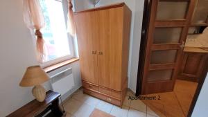 een kamer met een houten kast en een raam bij Apartament Rybacka 84/2 in Krynica Morska