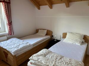 two twin beds in a room with a window at Sonnenchalet mit Sauna in Kötschach