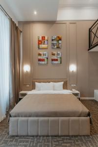 a bedroom with a large bed and two pictures on the wall at Callisto Hotel in Baku