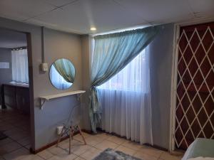 a room with a mirror and a window at Our Place - Family - 5 bed unit in Bloemfontein