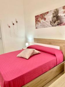 een slaapkamer met een bed met een roze deken bij La Casa di Nonna Nina in Carovigno
