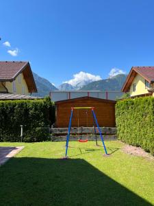 un columpio en el patio de una casa en Sonnenchalet mit Sauna, en Kötschach-Mauthen