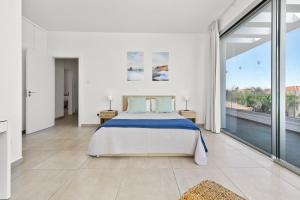 a white bedroom with a bed and a large window at Sea Point Villas Luxury Villas with Private Pools in Coral Bay in Coral Bay +157 photos