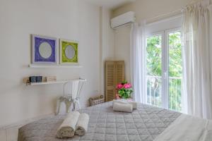 a white bedroom with a large bed with towels on it at Πολύ όμορφο και ζεστό διαμέρισμα. in Athens