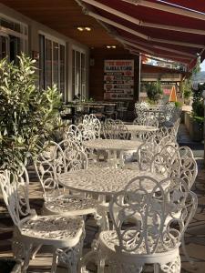 un grupo de mesas y sillas blancas en un patio en HOTEL AULONA FIER en Fier