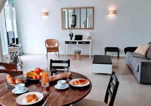 una sala de estar con una mesa con comida. en Le Petit Saint Jean - Residadigne - Zeperfectplace, en Digne-les-Bains