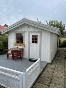 a white shed with a table on a deck at Mysigt och centralt in Strömstad