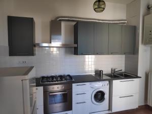 a kitchen with a stove and a washing machine at Appartamento Panoramica in Pesaro