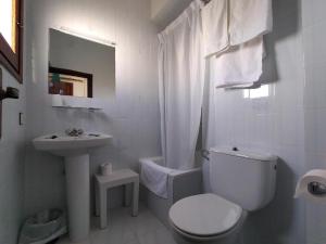 a white bathroom with a toilet and a sink at Hotel Rancho del Mar in Mojácar