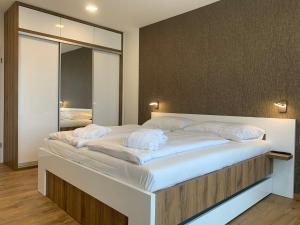 a large bed in a room with a large mirror at Wellness & Spa Apartments Lipno - Frymburk in Frymburk